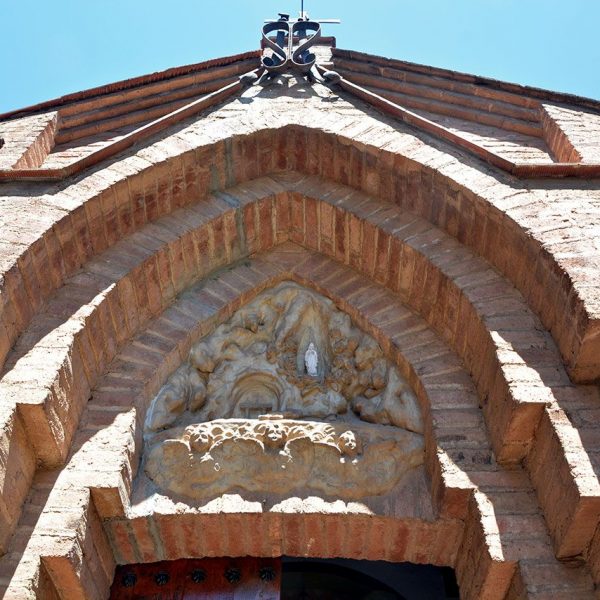 Barcelona.- Monestir de Sta. Maria de Valldonzella – Capella Nostra Senyora de Lourdes - Portalada d’arcs parabòlics amb un timpà al·lusiu a la gruta de Lourdes (6/2015)