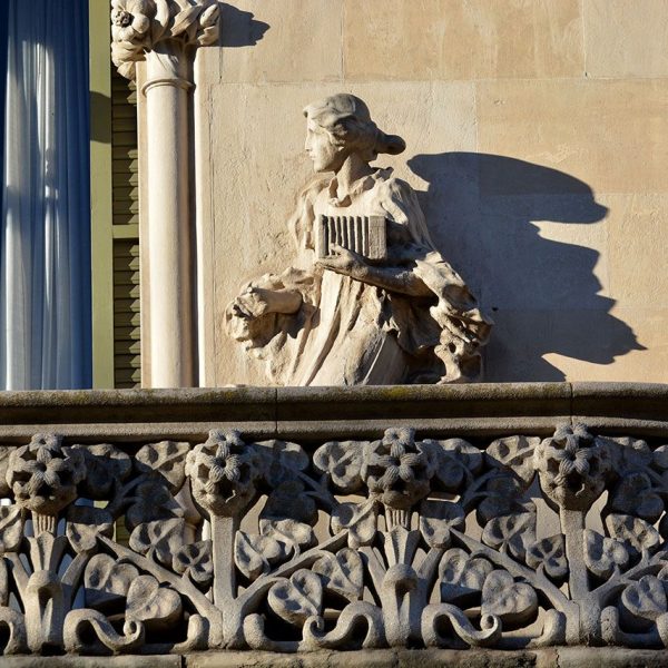 Barcelona.- Casa Lleó Morera de 1905 de Lluis Domènech i Montaner - Escultura femenina del balcó del segon pis portant una càmera fotogràfica (2/2015)