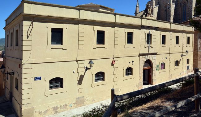 Montblanc.- Centre d’Interpretació de l’Art Rupestre, edifici neoclàssic que era l’antiga presó amb un escut dalt de la façana al·lusiva a la Justícia (4/2014)