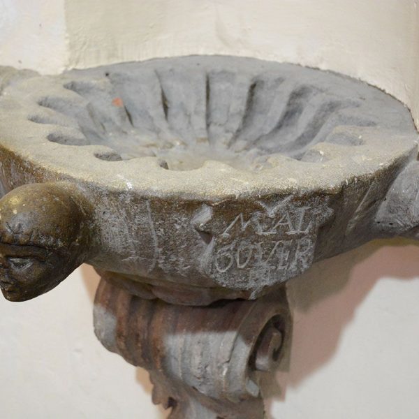 Olot.- Església neoclàssica de Sant Esteve, S. XVIII. Una de les piques beneiteres del S. XVIII decorades amb tres caps d'angels (12/2016)