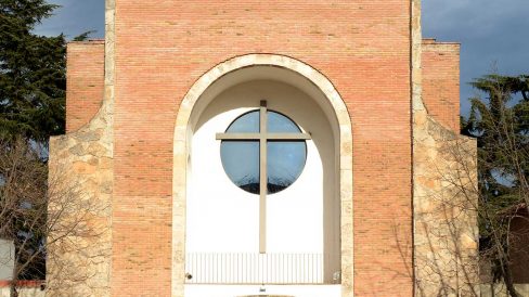 Olot.- Església de Sant Pere Màrtir. La façana consta d'una porta d'arc rebaixat i un balcó cobert amb una gran creu i òcul (12/2017)