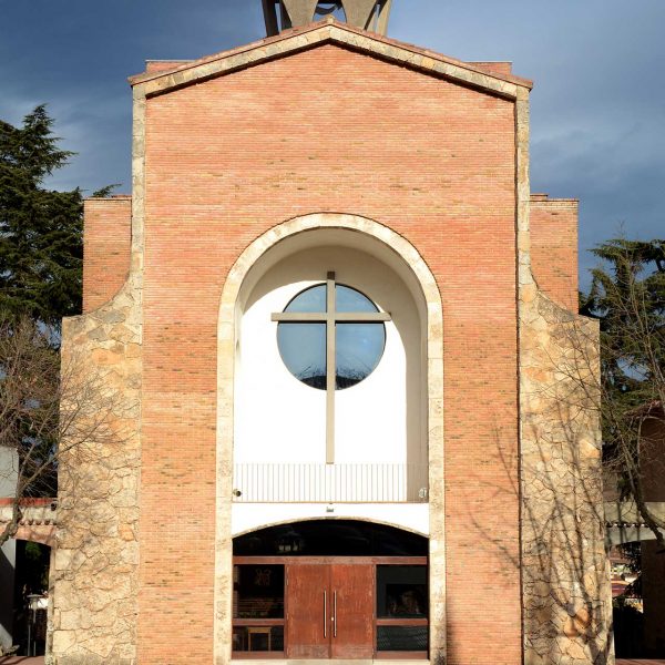 Olot.- Església de Sant Pere Màrtir. La façana consta d'una porta d'arc rebaixat i un balcó cobert amb una gran creu i òcul (12/2017)