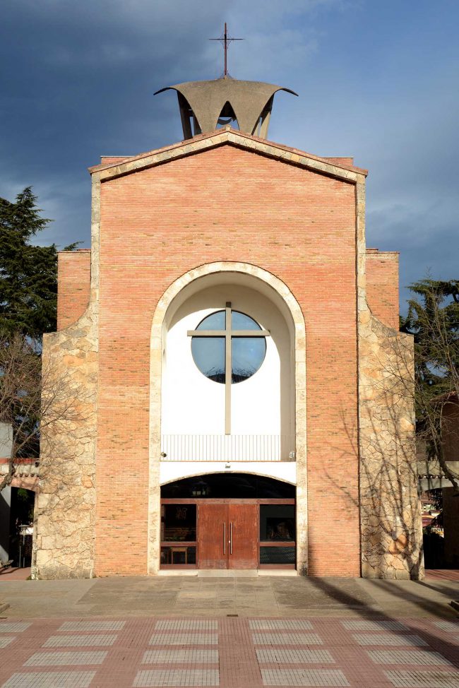 Olot.- Església de Sant Pere Màrtir. La façana consta d'una porta d'arc rebaixat i un balcó cobert amb una gran creu i òcul (12/2017)