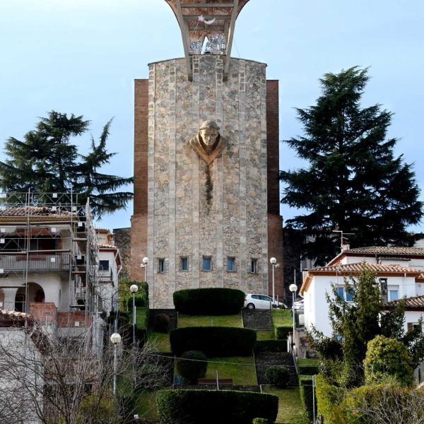Olot.- Església de Sant Pere Màrtir. A la façana posterior en el campanar hi ha el bust de Sant Pere esculpit per C. Devesa. (12/2017)
