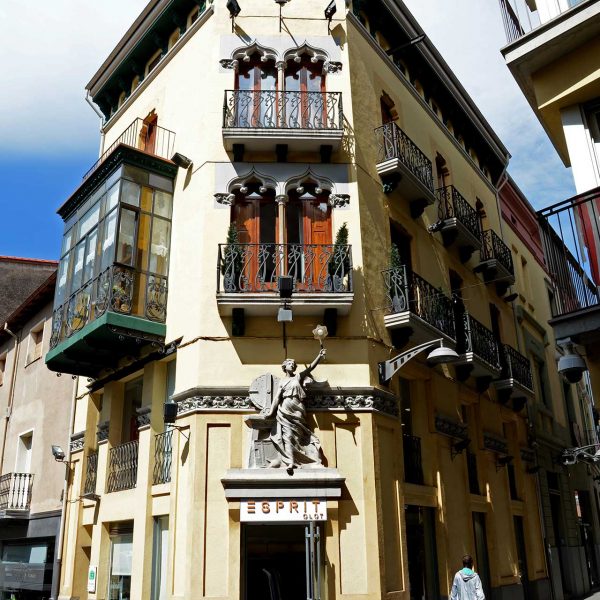 Olot.- Casa Gassiot, d'estil modernista del S. XX amb tres façanes. La central té una figura al·legòrica i dos pisos amb balcons (5/2017)