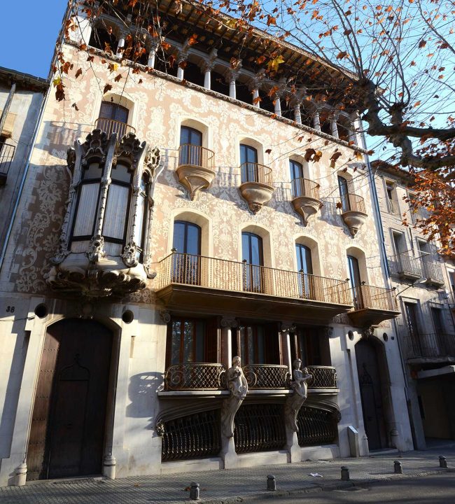 Olot.- Casa Solà Morales, d'estil modernista de Lluis Domènech i Montaner, S. XX. Destaquen a la planta baixa dues figures femenines (12/2016)
