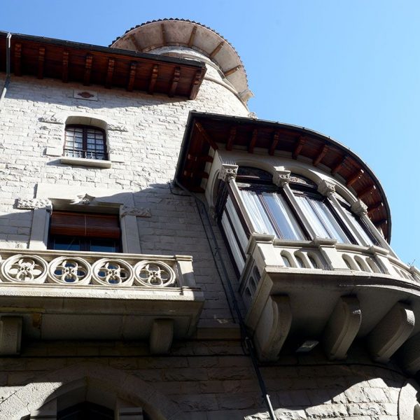 Olot.- Casa Pujadors, d'estil modernista-historicista del S. XX. Vista lateral amb balcons d'estil neogòtic i la tribuna cantonera (12/2016)