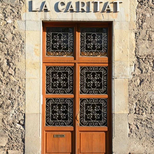 Olot.- Museu Comarcal ubicat a la tercera planta de l'antic Hospici del S. XVIII. Vista de la porta molt austera de la façana principal (4/2017)