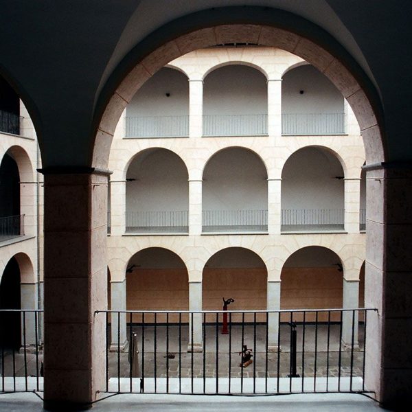 Olot.-Antic Hospici del S. XVIII i que està organitzat al voltant d'un gran pati de tres pisos amb galeries (6/1996)