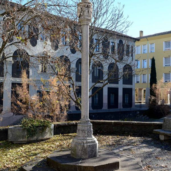 Olot.- Creu de terme de la Plaça Palau. Es tracta d’una reconstrucció feta de resina i pols de marbre d'uns fragments guardats a l'església de Sant Esteve (12/2016)