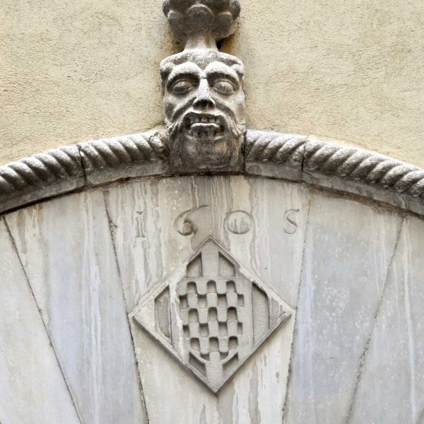 Girona.- Ajuntament, d'estil eclecticisme. Porta adovellada del pati interior amb l'escut de la ciutat. A sobre hi ha esculpida una cara (11/2013)