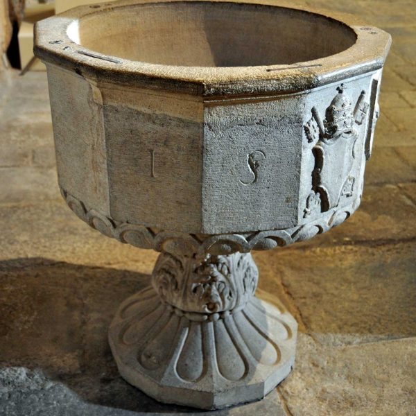 Girona.- Església de Sant Pere de Galligants, S. XII. Pica baptismal del 1550 de dotze cares i dos escuts esculpits (11/2013)