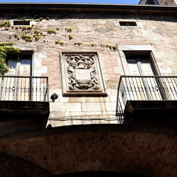 Girona.- Palau Agullana, S. XIV/XVI. Al centre del pont d'unió dels dos cossos del palau hi ha l'escut dels escultors Joan i Guillem Serra (5/2014)