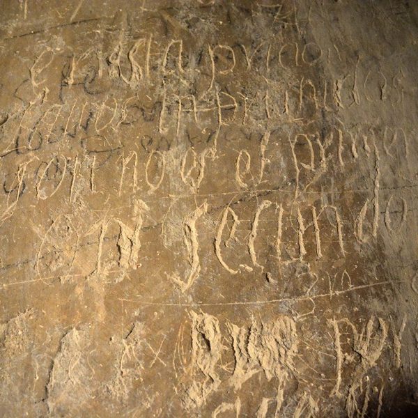 Girona.- Palau Episcopal, d'estil romànic/gòtic. Sala de la Presó o antiga presó dels capellans amb uns grafits gravats a la paret (2/2017)