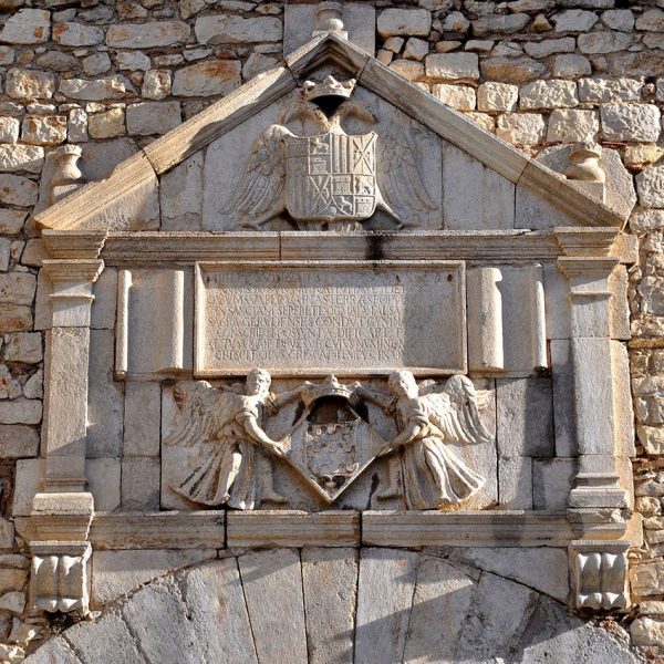 Girona.- Casa de les Àligues dels S. XVI/XX. Detall del frontó renaixentista on figuren els escuts de Girona i el reial dels Àustries (12/2013)