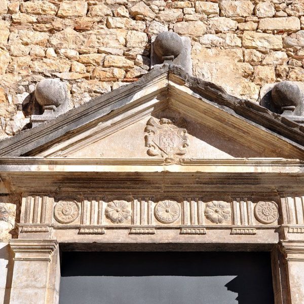 Girona.- Casa de les Àligues dels S. XVI/XX. Frontó triangular de la porta de la capella d'origen romànic beneïda el 1609 (11/2013)