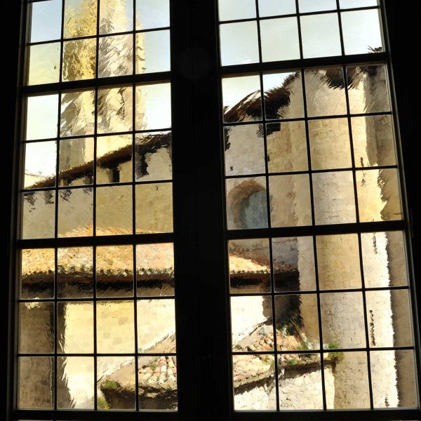 Girona.- Casa Pastors, S. XVII edificada sobre les muralles romanes. Sant Feliu vist a través de la vidriera d'una finestra del primer pis (5/2014)