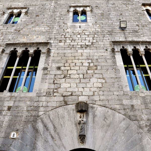 Girona.- Pia Almoina, d'estil gòtic S. XIII/XVII. Sector de la façana amb dues finestres trífores a la primera planta i tres de bífores a la segona (11/2013)