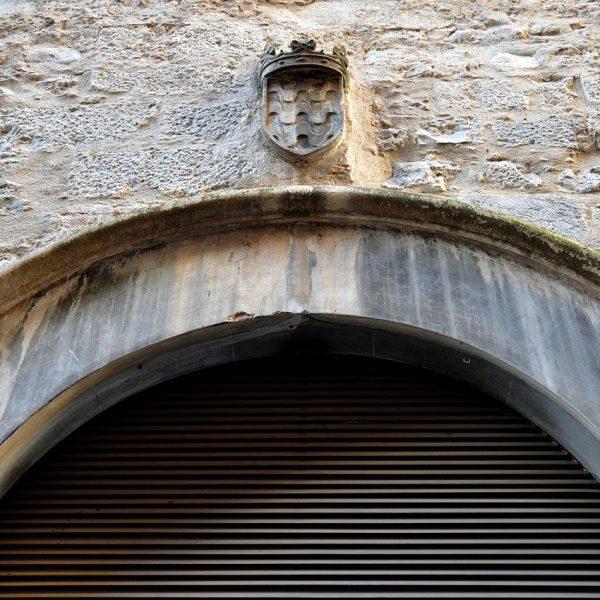 Girona.- Museu d’Història de Girona ubicat a la Casa Cartellà i antic convent dels caputxins. Vista de la primitiva porta amb l’escut Girona (2/2014)