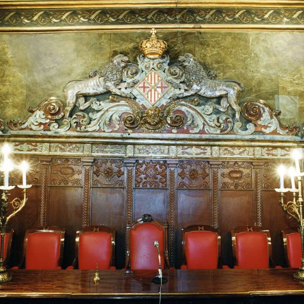 Vic.- Ajuntament, dels S. XIV a XVI. Saló de Plens de planta quadrada. Sobre la presidència hi figura l'escut de la ciutat (9/2000)