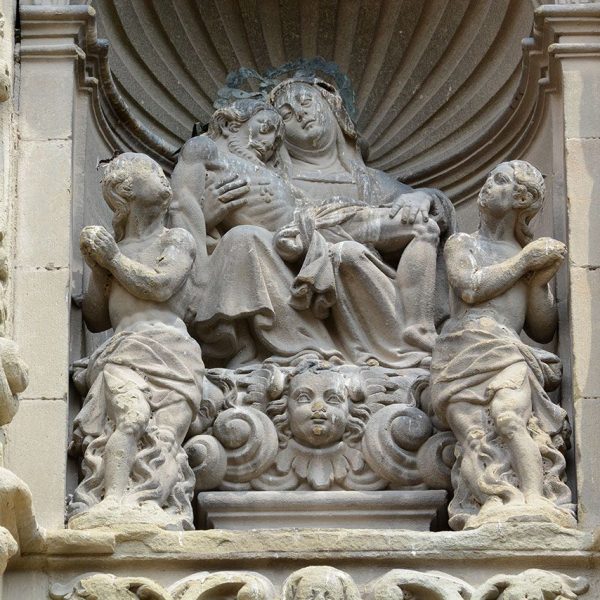 Vic.- Església barroca de la Pietat. Mare de Déu de la Pietat en una fornícula acompanyada de dues figures amb actitud beatífica (7/2018)