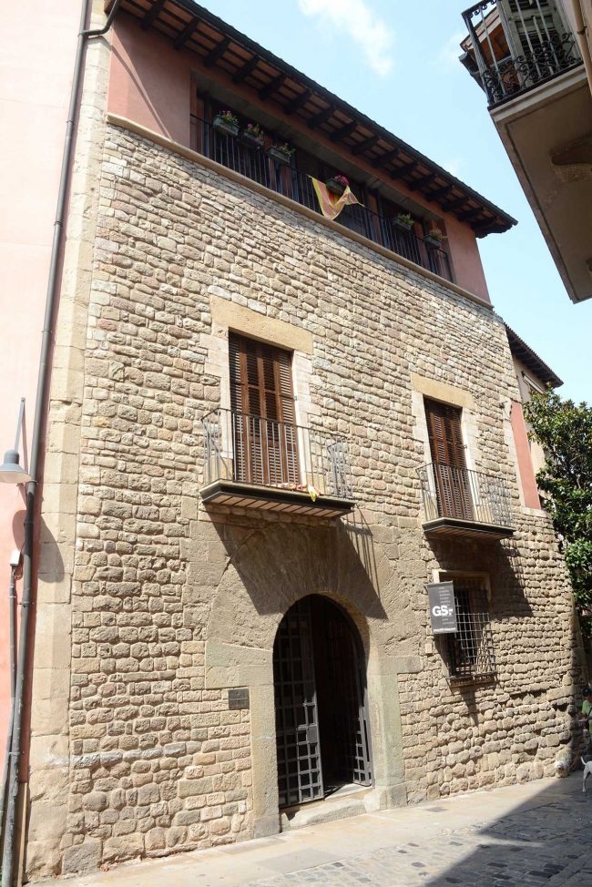 Vic.- Casa Clariana, gòtica/barroca del S. XVII/XVIII amb tres façanes. El cos oriental amb la porta principal adovellada de mig punt es de pedra (7/2018)