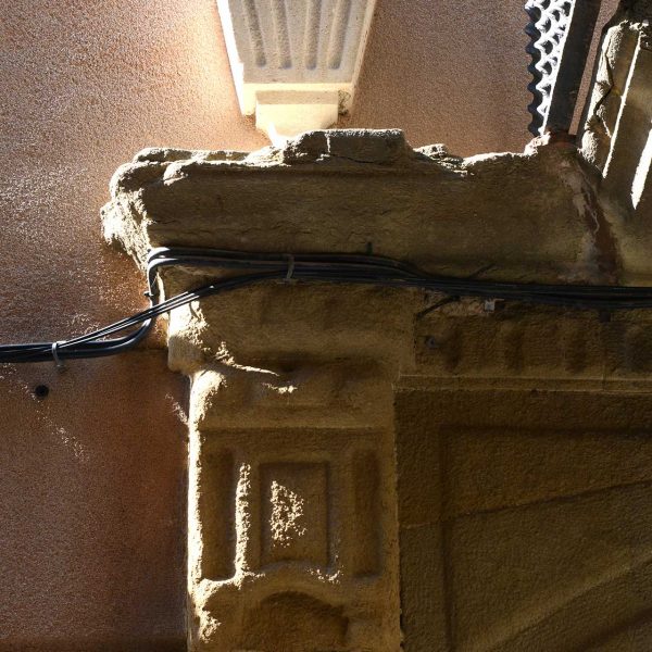 Vic.- Casa Cortada, S. XVII/XVIII d'estil barroc/eclèctic. La porta està flanquejada per brancals motllurats rematats per urnes (7/2018)