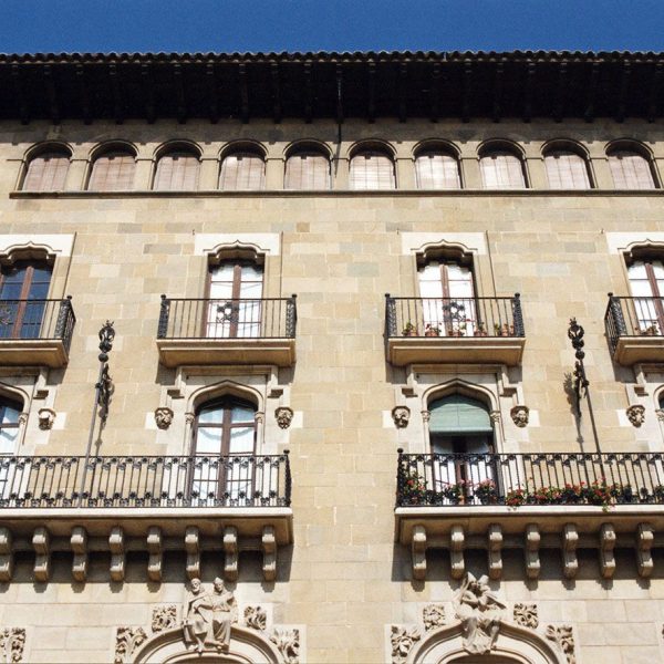 Vic.- Casa Costa d'estil modernista, S. XX. A la part baixa (balcons del primer pis) s'endevinen les escultures corresponents a les quatre classes socials (8/2000)