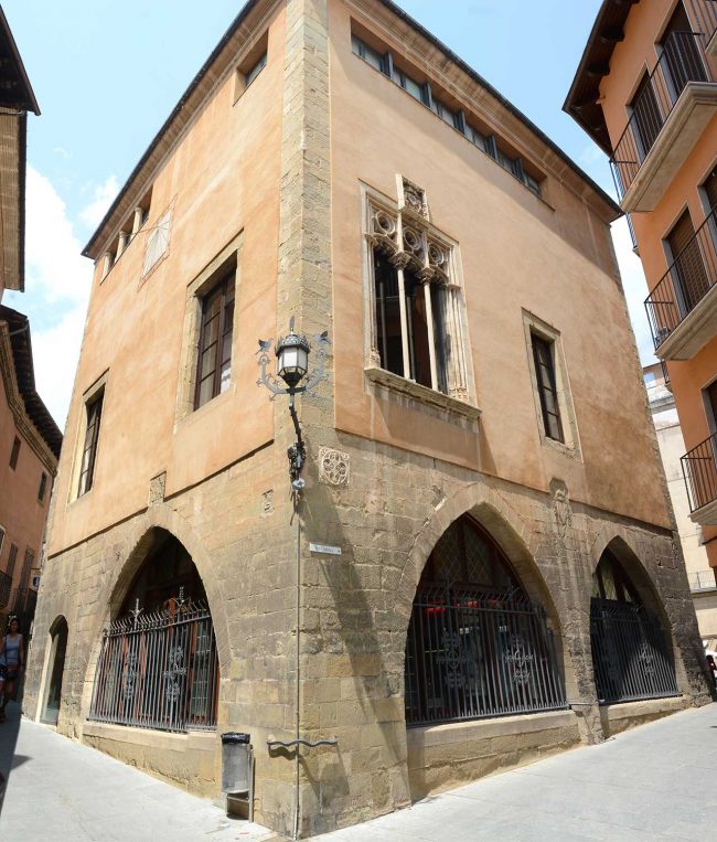 Vic.- Llotja del Blat. D’estil gòtic/barroc amb grans arcades obertes al laterals de la planta baixa que a la vegada corresponen a la oficina de turisme (7/2018)