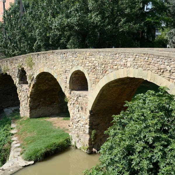 Vic.- Pont romànic de Queralt, S. XI molt modificat. Es de quatre arcs de mig punt de diferents mides. Entre les arcades hi ha oberts tres sobreeixidors (7/2018)
