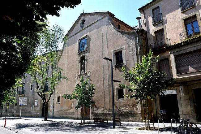 Vic.- Església de Sant Domènec, S. XVII. La porta es d'arc trevolat amb un escut bisbal i al damunt hi ha la Mare de Déu el Roser dins una fornícula (6/2020)