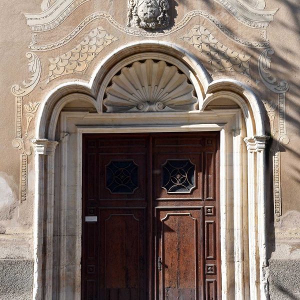 Vic.- Església de Sant Domènec, S. XVII. Porta d'arc trevolat amb una petxina al timpà i un escut al damunt (6/2020)
