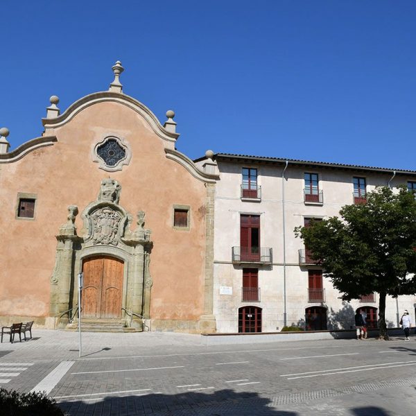 Vic.- Església barroca de la Santa Creu, S. XVIII. La porta de la façana està flanquejada per pilastres rematades amb florons i un escut al timpà (6/2020)