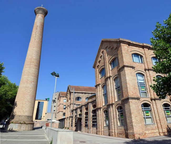 Vic.- Fàbrica de Sucre, S. XIX d'estil modernista en forma de U, destaca per la seva xemeneia cònica. Actualment acull diverses institucions i activitats culturals (6/2020)