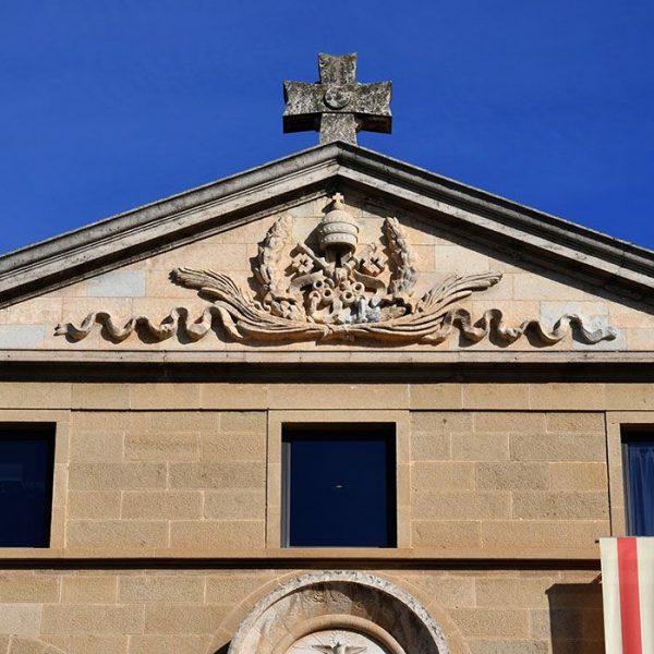 Vic.- Seminari Conciliar es un edifici en forma de creu. Frontó triangular que corona la façana amb la tiara papal dins el timpà i una creu al damunt (2/2020)