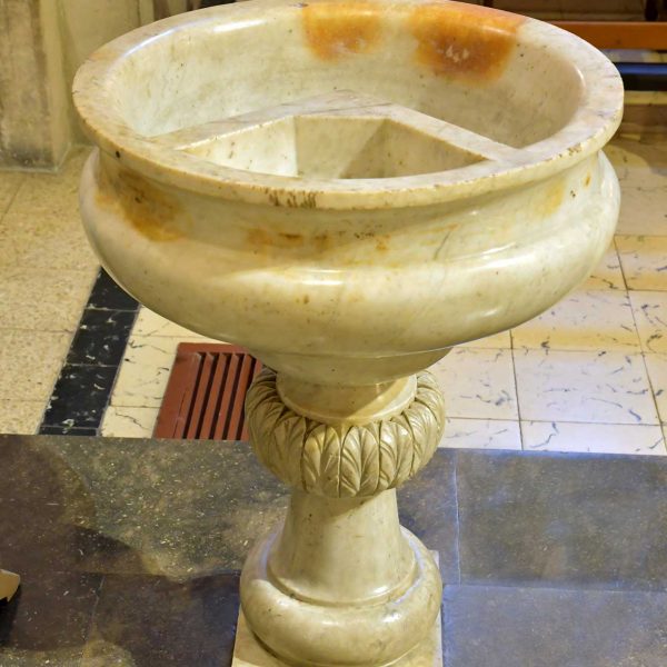 Lleida.- Església barroca de Sant Pere, S. XVIII. Pica baptismal circular formada per dos compartiments interiors sobre un pilar adornat amb fullatges (9/2020)