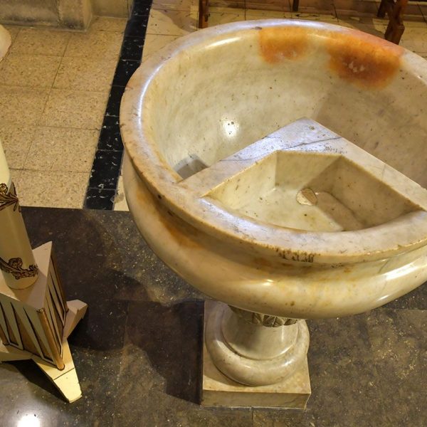 Lleida.- Església barroca de Sant Pere, S. XVIII. Pica baptismal circular formada per dos compartiments interiors sobre un pilar adornat amb fullatges (9/2020)