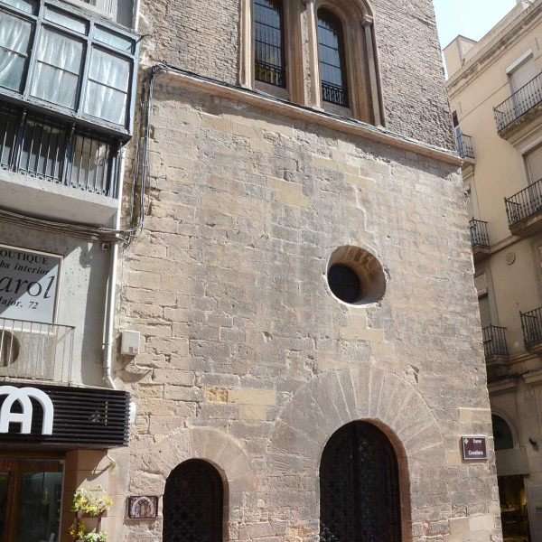 Lleida.- Capella gòtica de Sant Jaume o Peu del Romeu, S. XIV. Façana lateral amb dues portes d'arc de mig punt i al pis una finestra biforada i un òcul (9/2018)