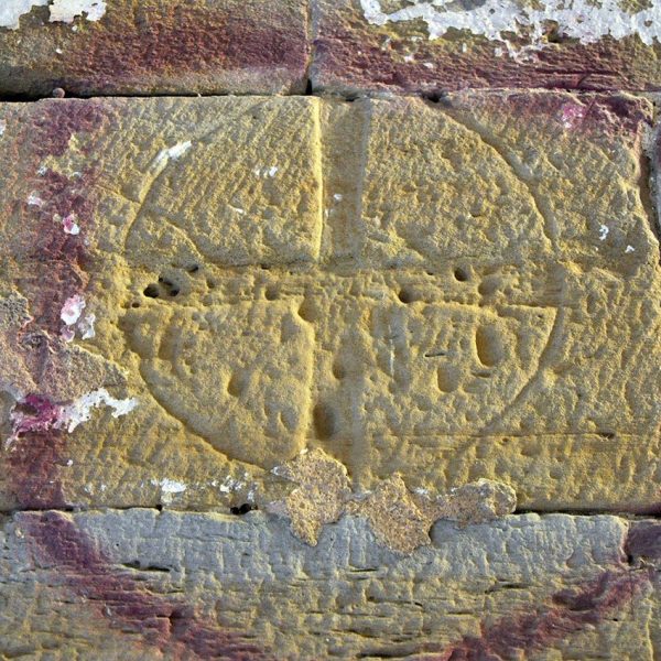 Lleida.- Església romànica de Santa Maria del castell, S. XII. Creu patent gravada dins un cercle de les que se'n troben varies repartides per la nau (5/2010)