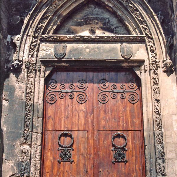 Lleida.- Església de S. Llorenç, S. XII d'estils romànic i gòtic. Porta d'arc conopial amb ornamentació floral i a la llinda hi ha els escuts de la família Gallart (9/1992)