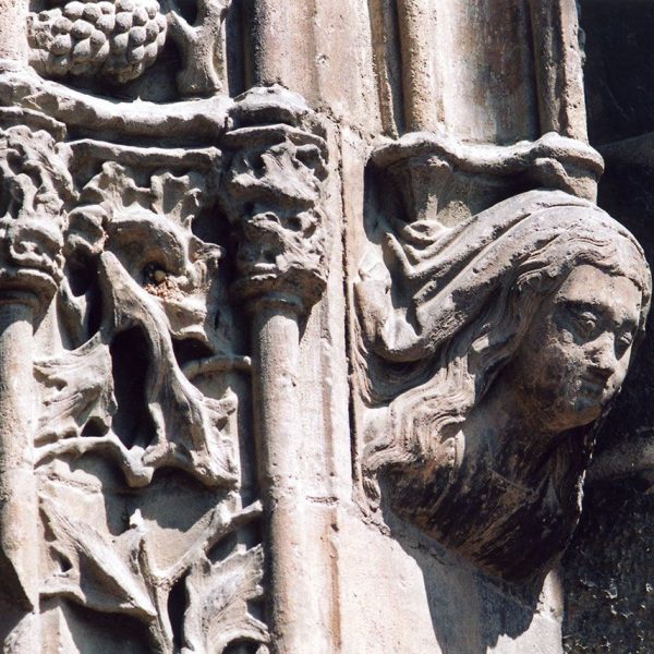 Lleida.- Església de Sant Llorenç, S. XII d'estils romànic i gòtic. Mènsula decorada amb cap de dona en una de les arcades de la porta (9/1992)