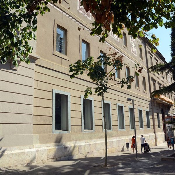Lleida.- Biblioteca pública, edifici de l'antiga maternitat del S. XIX d'estil eclèctic de composició simètrica amb balconada central i diversos esgrafiats al primer pis (9/2018)