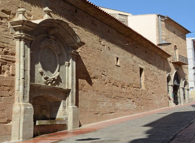 Lleida.- Parador de Lleida ubicat a l'antic convent barroc del Roser, S. XVII. La porta consta de tres arcades ogivals i en un extrem trobem la font del Roser (9/2018)