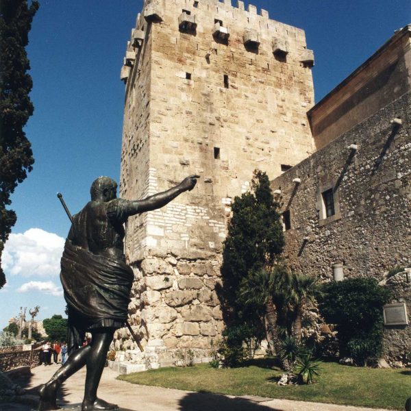 Tarragona.- Torre de l’Arquebisbe construïda amb carreus romans sobre un sòcol megalític. Davant veiem la reproducció d’una estàtua d’August (4/1999)