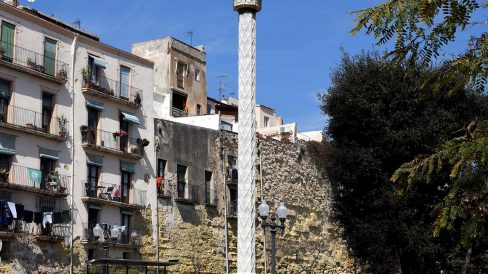 Tarragona.-Creu de terme del S. XVII del portal de S. Antoni sobre un peu quadrat datat de 1604. La magolla es vuitavada amb imatges de sants (3/2021)