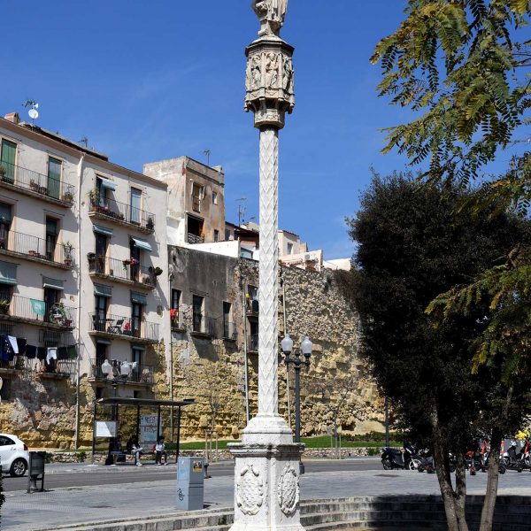 Tarragona.-Creu de terme del S. XVII del portal de S. Antoni sobre un peu quadrat datat de 1604. La magolla es vuitavada amb imatges de sants (3/2021)