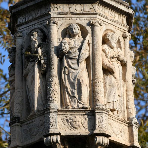 Tarragona.-Creu de terme del S. XVII del portal de S. Antoni. Magolla octogonal on hi ha esculpits vuit sants dins fornícules (3/2021)