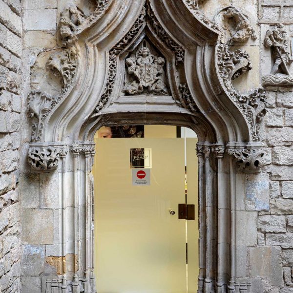 Barcelona.- Palau Aguilar (Museu Picasso) del S. XII reformat en el XV – Porta flamígera del replà de l’escala adornada amb un escut rodejat de cinc àngels (12/2016)