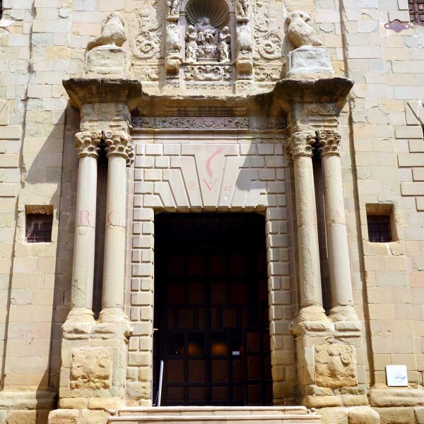 Vic.- Església barroca de la Pietat. La porta flanquejada per dues parelles de columnes té al damunt una fornícula amb la imatge de la Mare de Déu (8/2018)