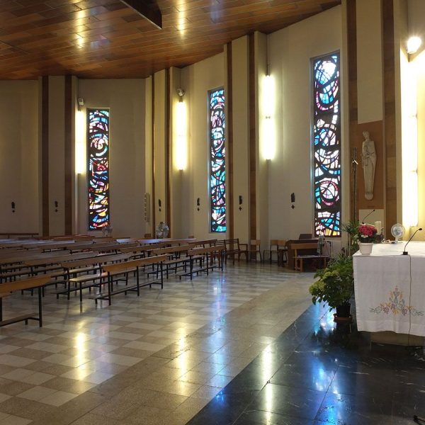 Tortosa.- Església Mare de Déu dels Dolors inaugurada l’any 1970 – Vista de l’altar i lateral il·luminat per finestrals allargats de vitralls de colors (7/2012)